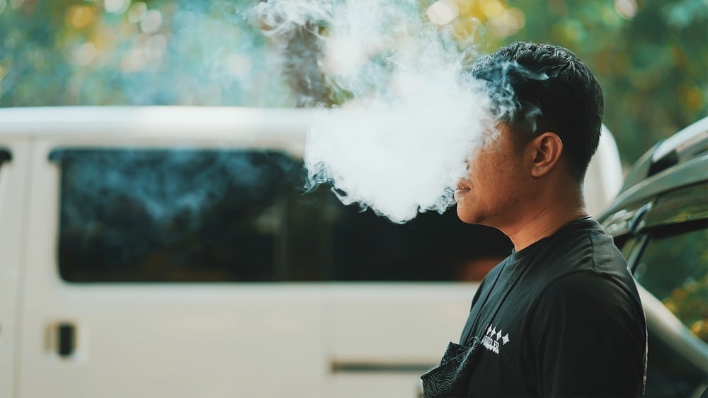 man in black crew neck shirt smoking - Effectiveness Of Vaping In Nicotine Replacement Therapy